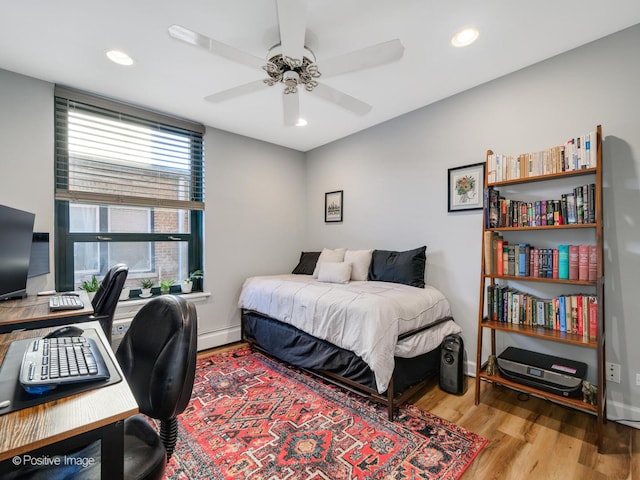 bedroom featuring baseboards, baseboard heating, light wood-style flooring, and recessed lighting