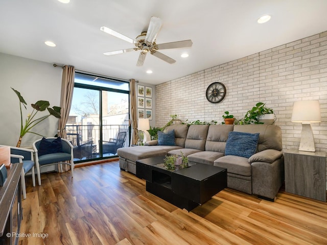 living area with recessed lighting, ceiling fan, brick wall, and wood finished floors