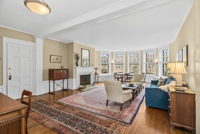 living room featuring a fireplace with flush hearth, ornamental molding, wood-type flooring, and a wealth of natural light