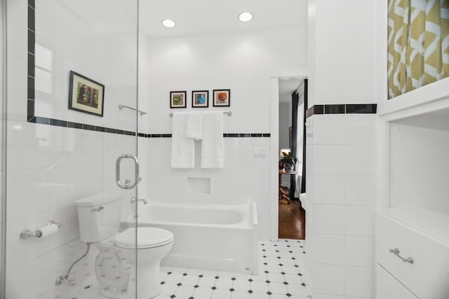 full bathroom with toilet, tile walls, wainscoting, walk in shower, and a bathtub