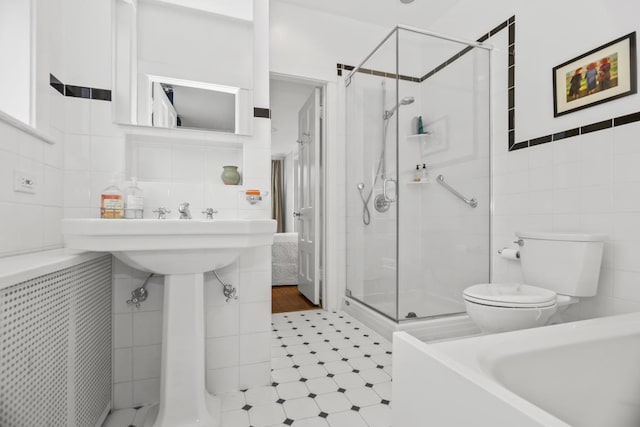 full bathroom featuring toilet, a stall shower, and tile walls