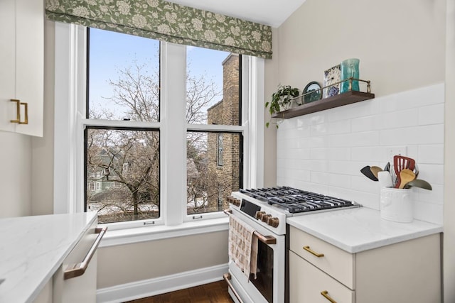 kitchen featuring open shelves, light stone counters, gas range gas stove, and white cabinets