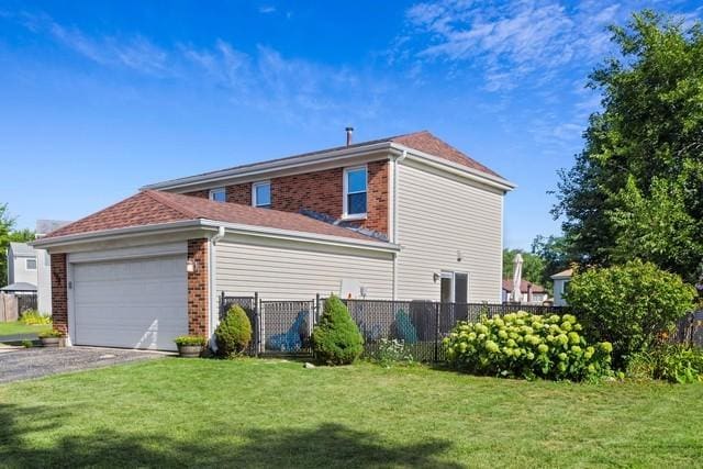 view of side of home with a garage and a lawn