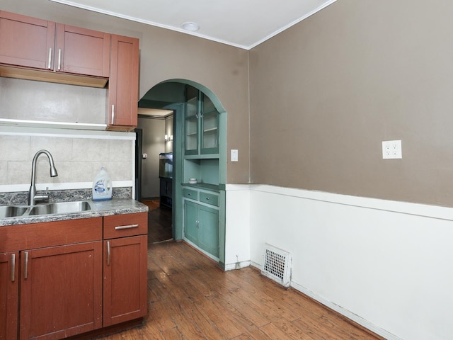 kitchen with sink, crown molding, dark hardwood / wood-style floors, and decorative backsplash