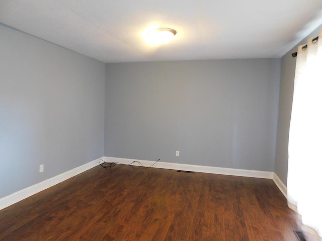 spare room with dark hardwood / wood-style flooring