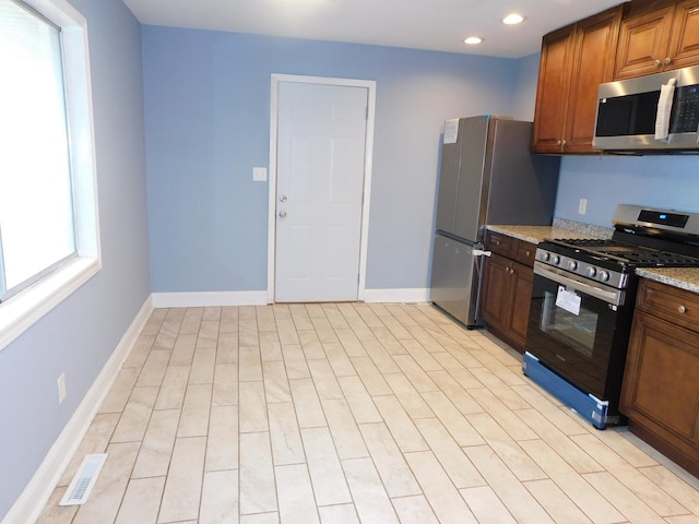 kitchen with appliances with stainless steel finishes and light stone countertops