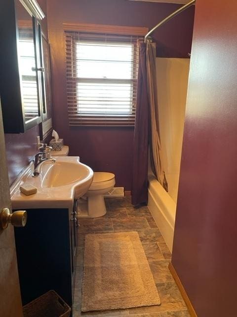 bathroom featuring toilet, shower / bath combo, a wealth of natural light, and vanity