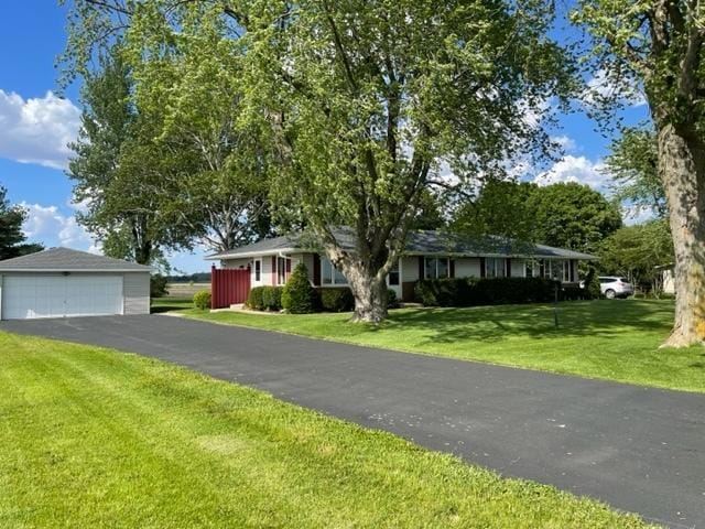 ranch-style home with a garage, an outdoor structure, and a front lawn