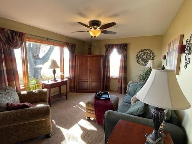 living area with light carpet, ceiling fan, and plenty of natural light