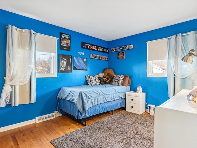 bedroom featuring visible vents, baseboards, and wood finished floors