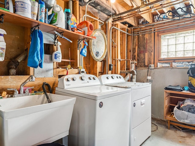 clothes washing area with laundry area, washer and dryer, and a sink