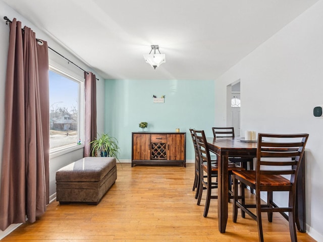 dining room featuring light wood-style flooring and baseboards