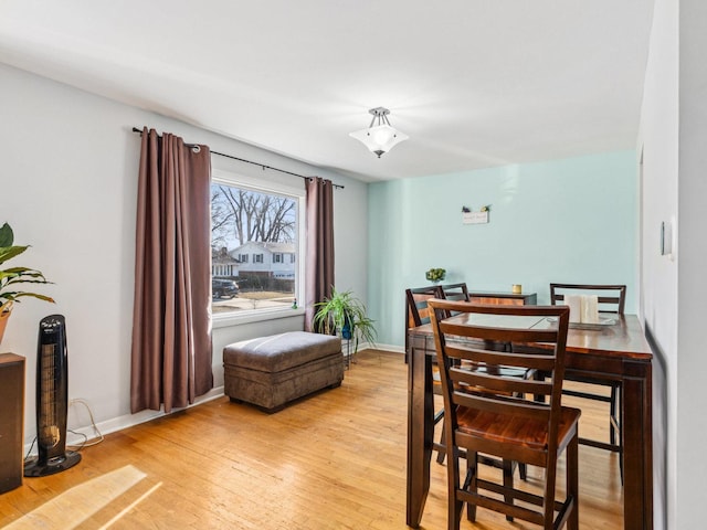 dining room with baseboards and light wood finished floors