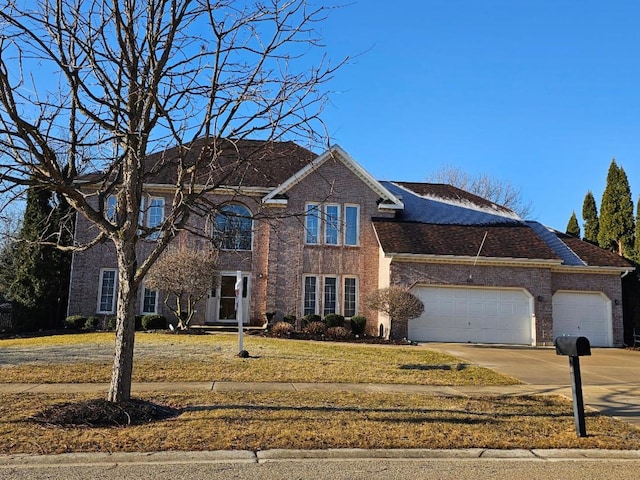 view of front of home featuring a garage, brick siding, driveway, and a front yard