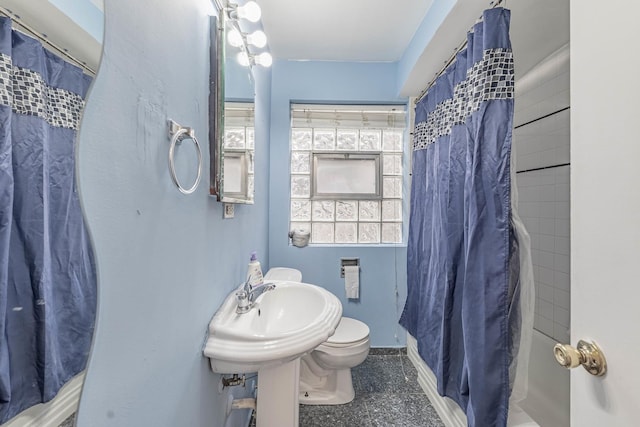 bathroom with curtained shower and toilet