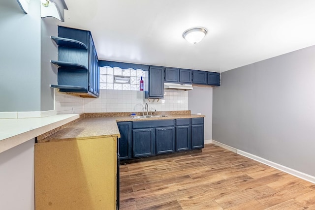 kitchen featuring blue cabinets, sink, backsplash, and light hardwood / wood-style flooring