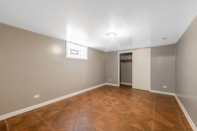 unfurnished bedroom with parquet flooring and a closet