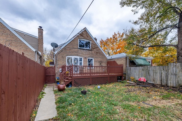 rear view of property with a deck and a lawn