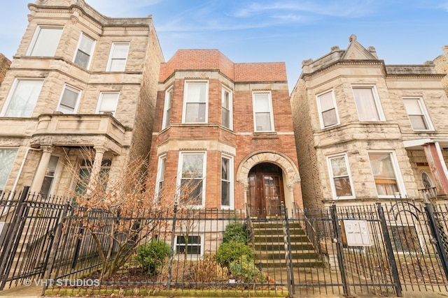 townhome / multi-family property with a fenced front yard and a gate