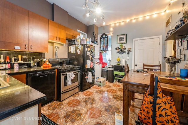 kitchen featuring dark countertops, black appliances, dark tile patterned floors, and visible vents