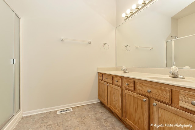 full bathroom featuring a sink, double vanity, visible vents, and a stall shower