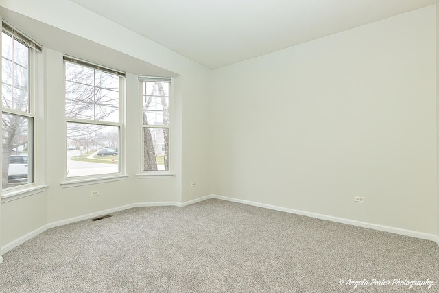 carpeted empty room with baseboards and visible vents