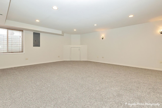 carpeted spare room with baseboards, electric panel, and recessed lighting