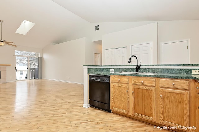 kitchen featuring a sink, dishwasher, open floor plan, dark countertops, and light wood-style floors
