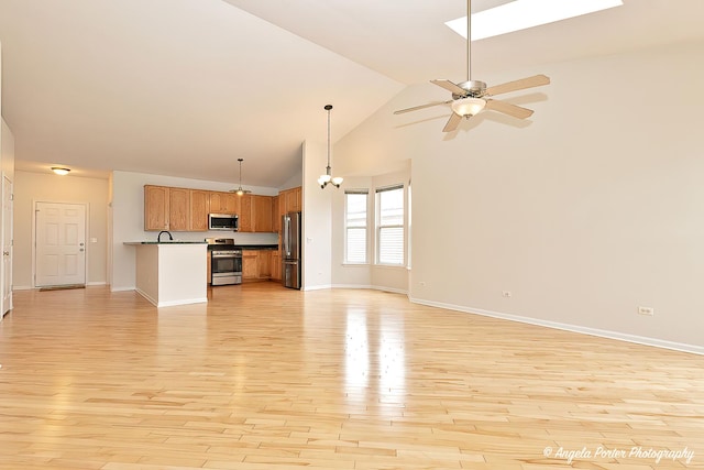 unfurnished living room featuring a ceiling fan, high vaulted ceiling, baseboards, and light wood-style floors