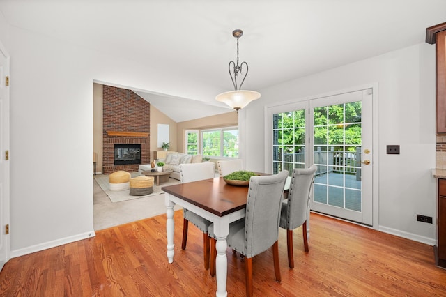 3444 Owens Ln, Dekalb, IL 60115 - dining area featuring light wood-style flooring, a brick fireplace, and vaulted ceiling