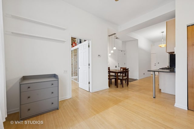 interior space featuring dark countertops, light wood-style flooring, and baseboards