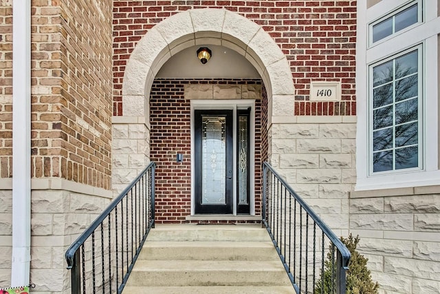 view of exterior entry featuring brick siding