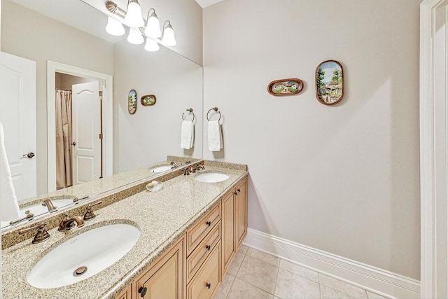 bathroom with tile patterned floors, baseboards, double vanity, and a sink