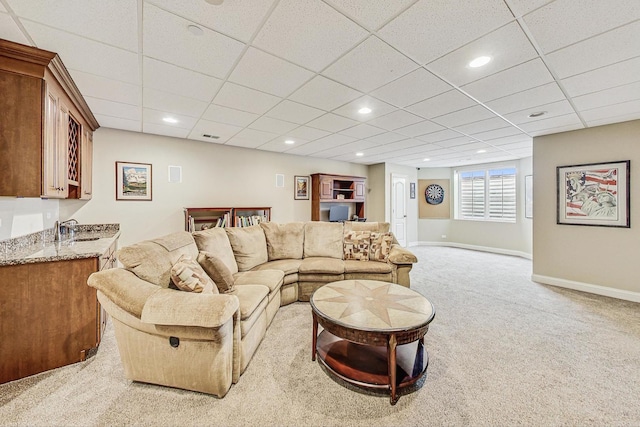 living room with recessed lighting, light colored carpet, a paneled ceiling, and baseboards