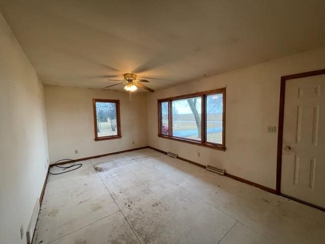 unfurnished room with ceiling fan, visible vents, and baseboards