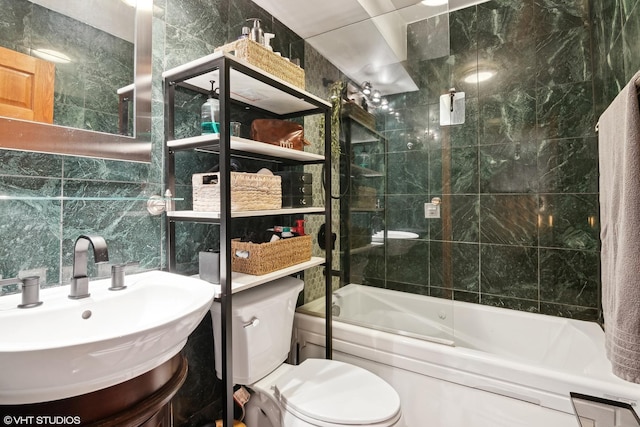 full bathroom featuring tiled shower / bath combo, vanity, tile walls, and toilet