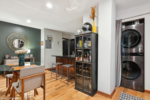 interior space with stacked washer and clothes dryer and light hardwood / wood-style floors