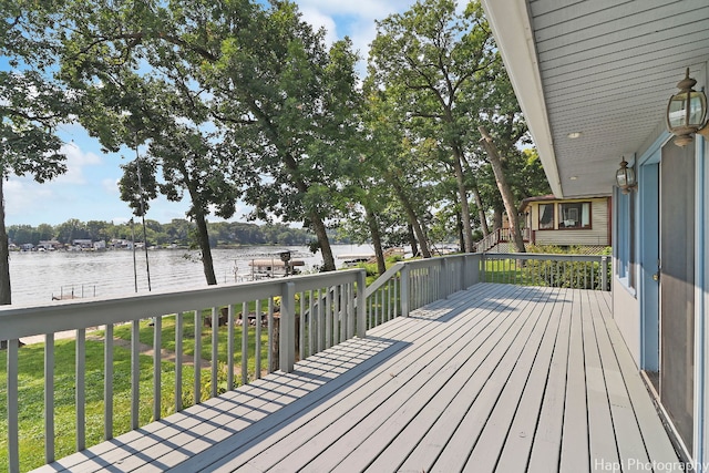 wooden deck featuring a water view and a yard