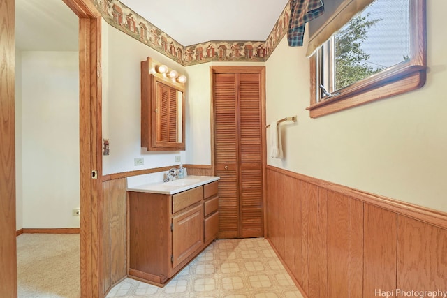 bathroom featuring vanity and wooden walls