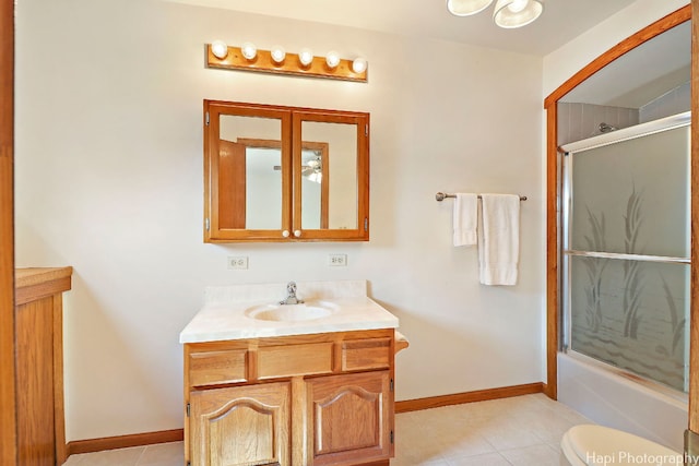 full bathroom with tile patterned flooring, vanity, combined bath / shower with glass door, and toilet