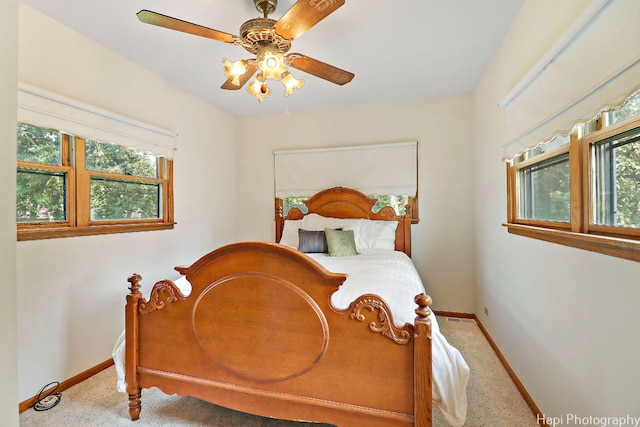 carpeted bedroom with ceiling fan and multiple windows