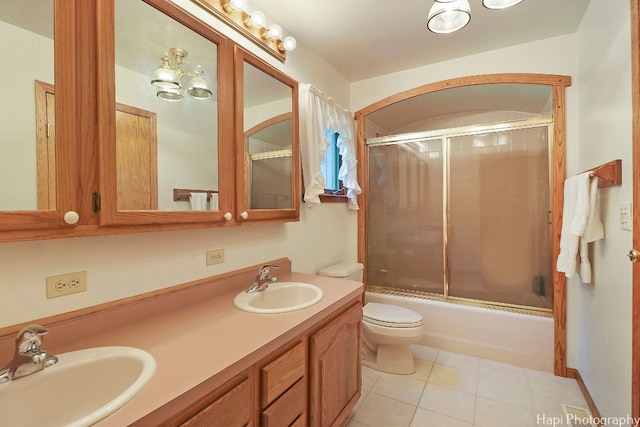 full bathroom with tile patterned flooring, vanity, combined bath / shower with glass door, and toilet