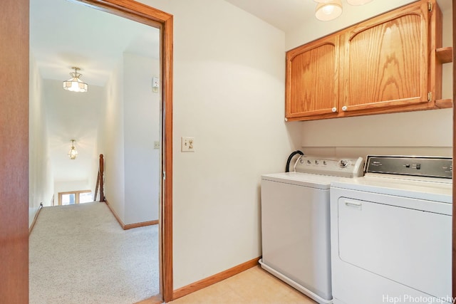 washroom with cabinets and washing machine and clothes dryer