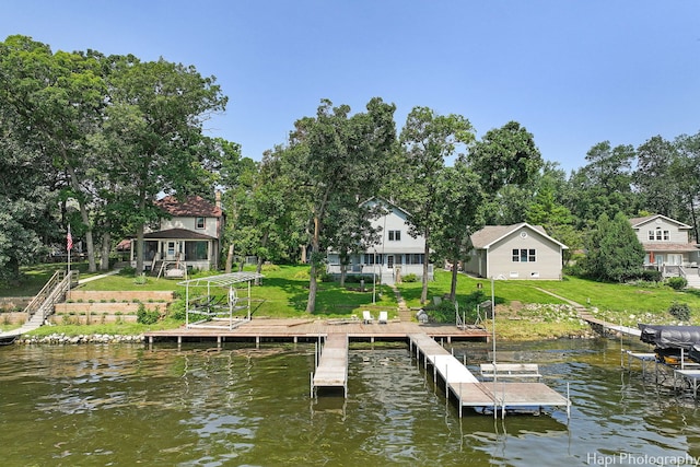 dock area with a water view and a yard