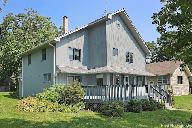 back of house featuring a wooden deck and a lawn