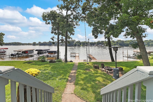 view of dock with a water view and a lawn