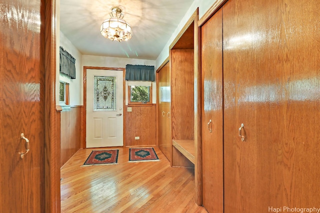 doorway to outside with a notable chandelier and light wood-type flooring