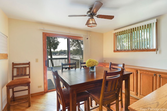 dining room featuring light hardwood / wood-style flooring, ceiling fan, and a water view