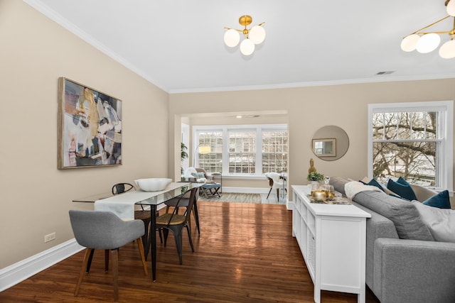 dining space featuring crown molding, dark wood-type flooring, and a chandelier