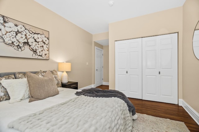 bedroom with dark wood-type flooring and a closet